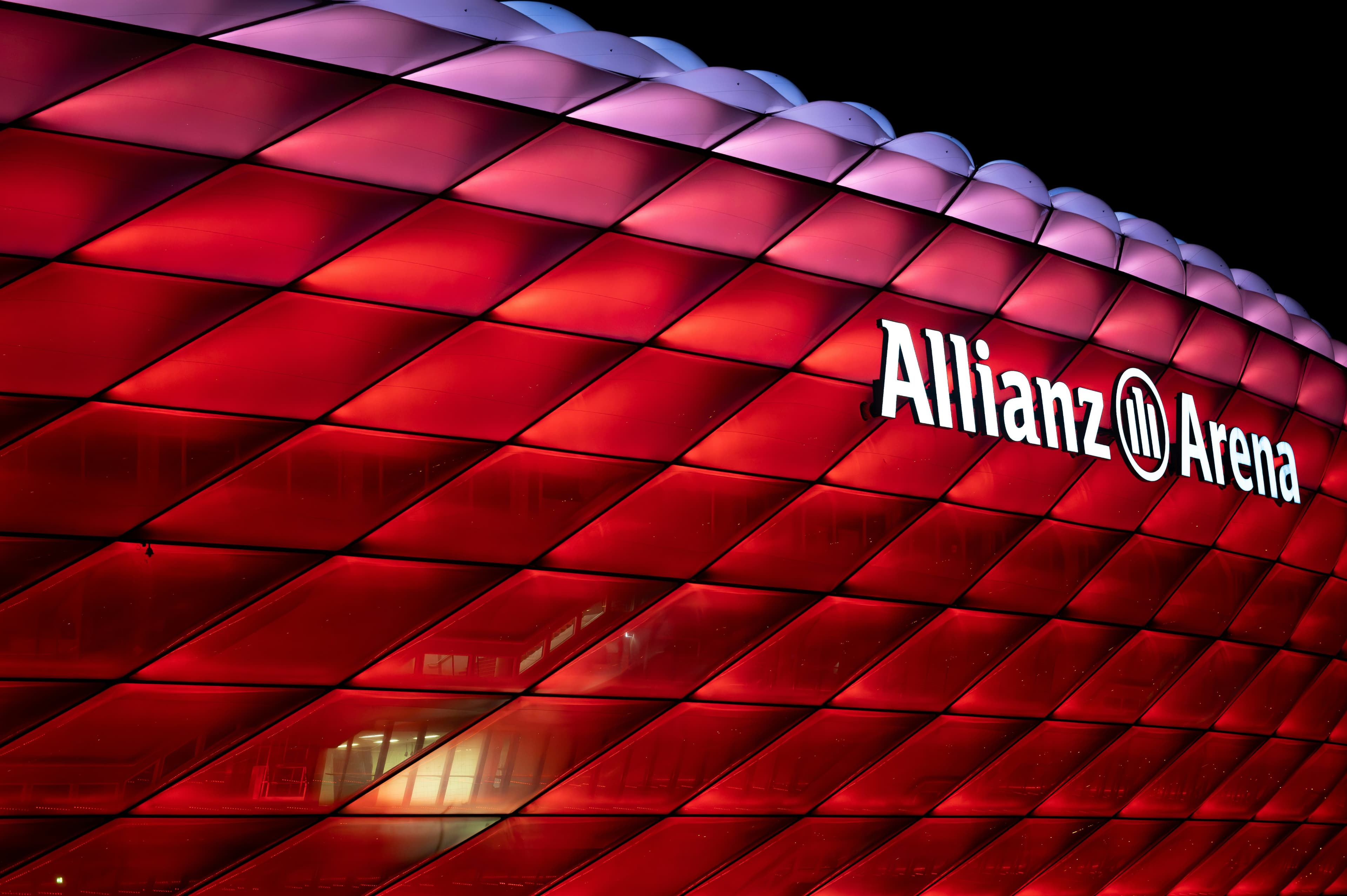 The distinctive red exterior panels of the Allianz Arena with FC Bayern München branding.