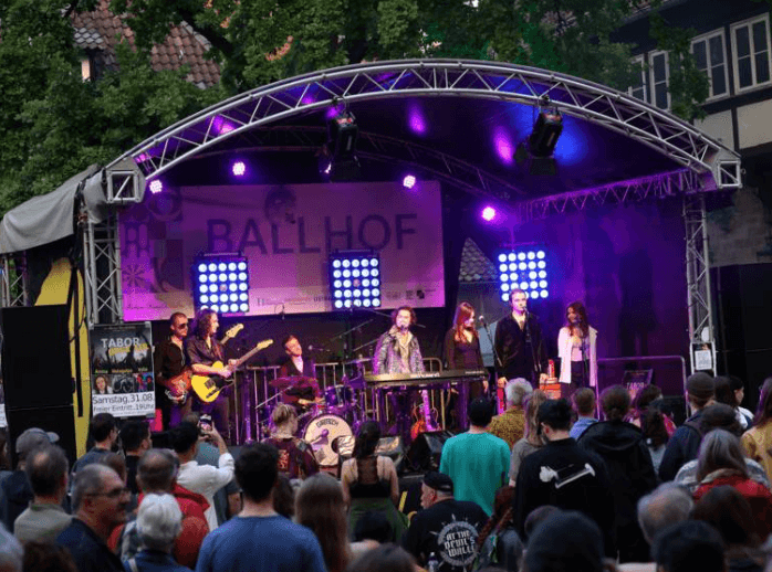 Live stage with a band at the Fête de la Musique in Hanover at dusk.