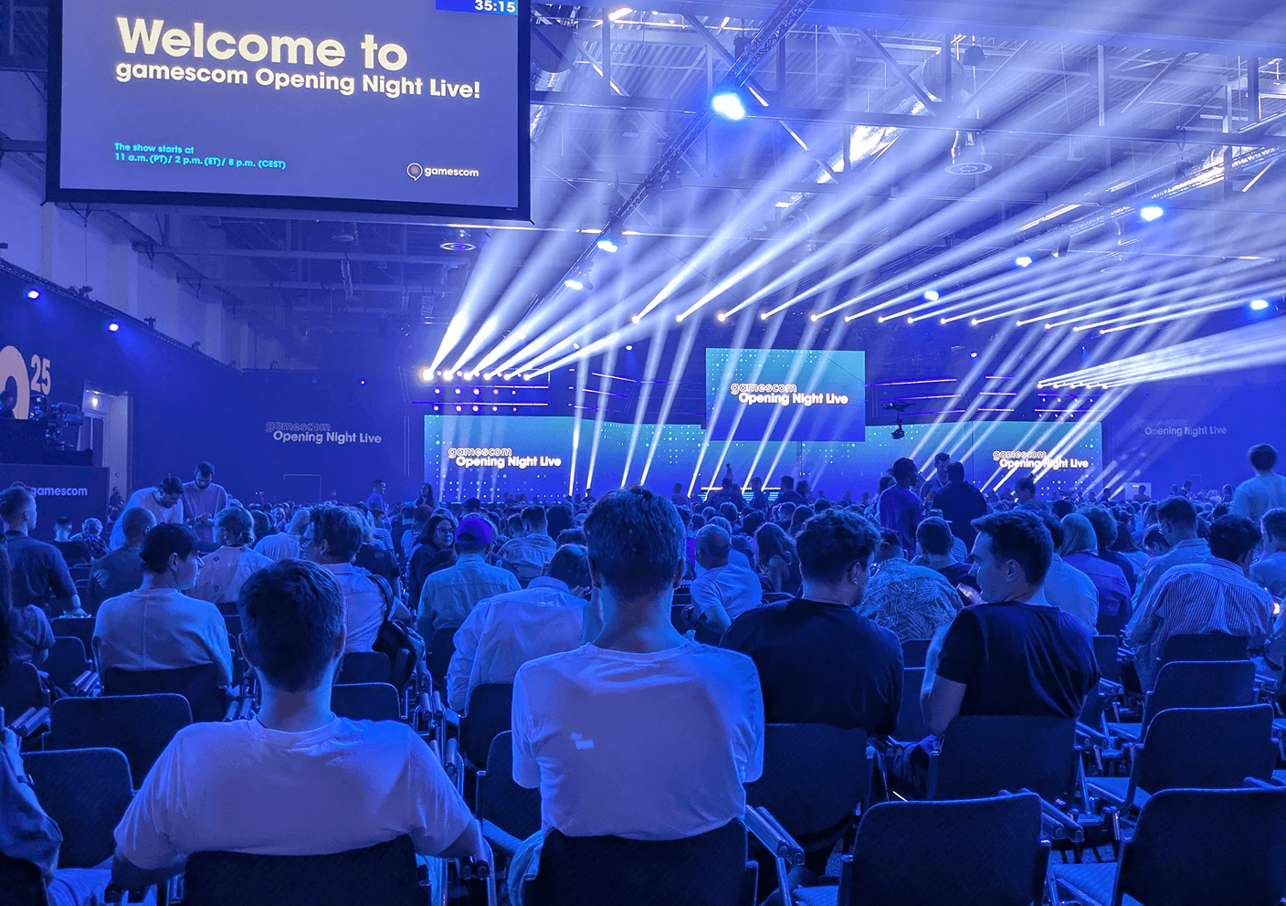 Audience in front of a stage with lights and a screen showing 'Welcome to gamescom Opening Night Live!'.