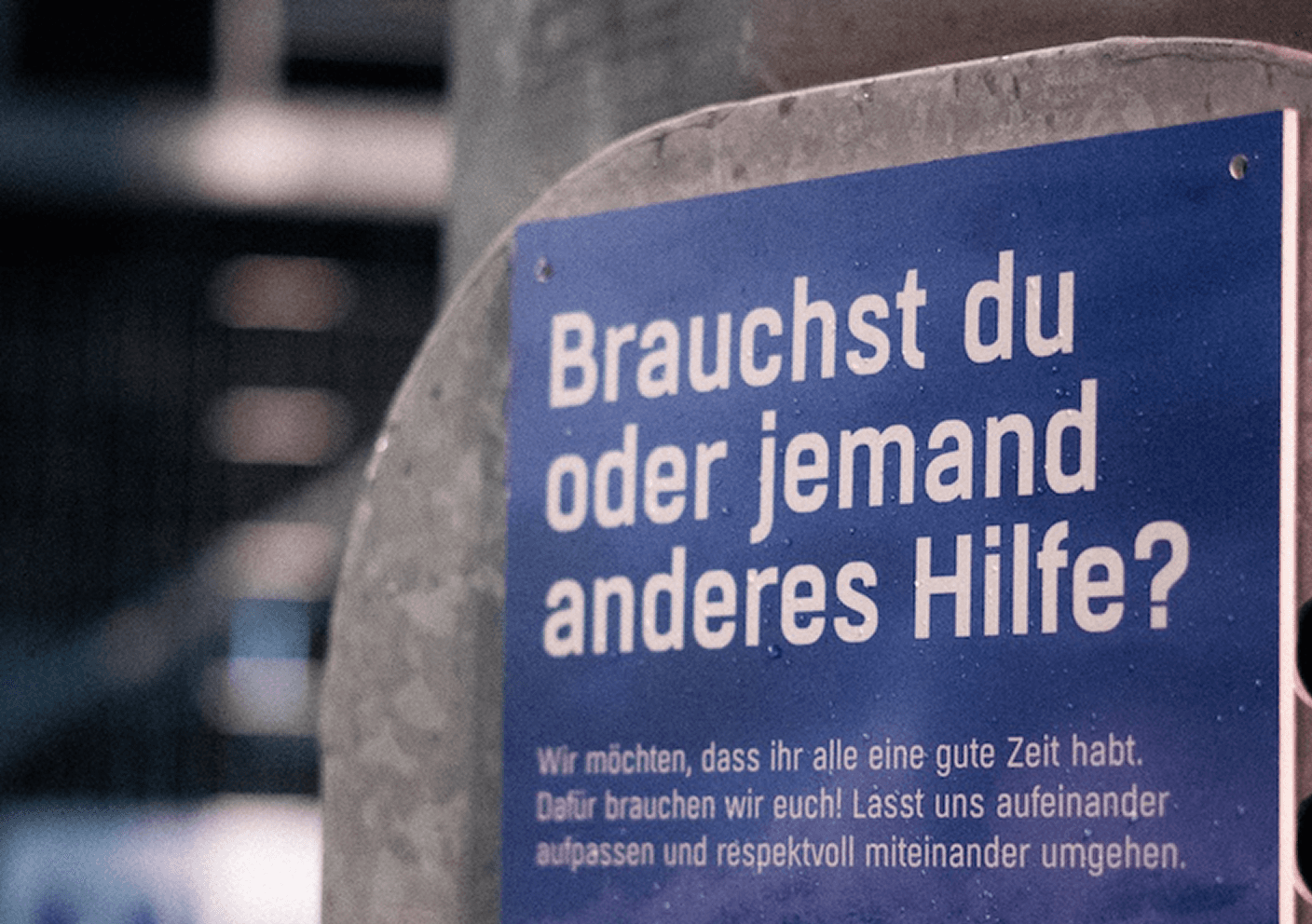 Blue stadium sign reading 'Do you or someone else need help?' with QR code.