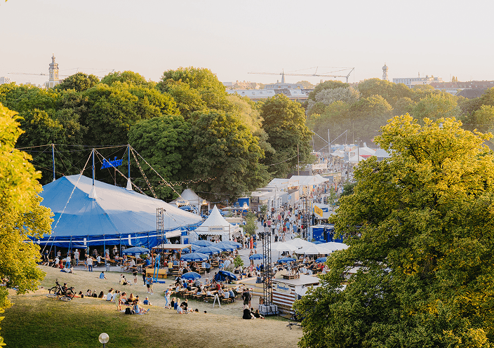 Aerial view of the Tollwood festival in Munich's Olympiapark at sunset.